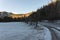 Landscape of mountain and snowy frozen road at sunset. Dangerous driving in winter, cold weather