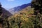 Landscape with mountains, forest and pines, cottages, mountain houses, blue sky, clouds, twisting road & terrace farms.