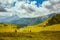 landscape with mountains, hills, clouds, meadow and trees