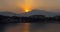 Landscape of mountains and lake during dawn time in the morning sun rising behind the clouds and Tyndall effect on water.