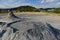 Landscape with mud volcanos with small eruptions and mountains