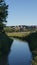 Landscape with narrow river flowing through lush green vegetation in Canadian Badlands