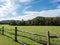 Landscape nature scene in the Laurel Highlands of Pennsylvania with a fence in the foreground and a meadow and tree line in the