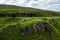 The landscape near the Faerie Castle Castle Ewen at the Fairy Glen in Isle of Skye in Scotland with hiking tourists