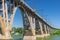 Landscape with an old Merefo-Hersonsky arched bridge over Dnipro river