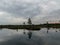 Landscape with old peat bogs and swamp vegetation. The bog pond reflects small pines, bushes and cloudy skies. Niedraju Pilkas