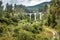 Landscape with old viaduct, Filisur, Switzerland. Scenic view of high railway bridge in Alps. Scenery of green forest and rural