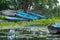 Landscape with old wooden rowing blue boats landing on green riverbank