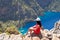 Landscape Oludeniz, Turkey, a young girl in a red dress looks at the Butterfly Valley from above, sitting on the rocks