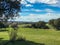 Landscape of one cottage and holm oaks on the pasture with blue sky and clouds at springtime in Spain