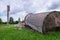 Landscape with overturned old water tower, wooden barrel on the ground, fragments of white brick ruins, Latvia, Vaidava