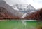 Landscape Pearl Lake with Chenrezig Xiannairi Holy Snow Mountain background at Yading winter season. It is beautiful green lake