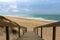 Landscape photo of boardwalk going down to empty sandy beach