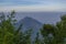 Landscape photo of mountain taken from highland with tree and bushes foreground