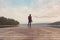 Landscape photographer at lake pier in misty morning