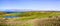 Landscape in Point Reyes National Seashore with Tule Elks grazing on the grasslands close to a pond; The Pacific Ocean visible in