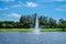 Landscape pond with a fountain and wide green lawns