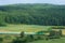 Landscape with a railway line, train, hills and fo