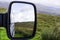 Landscape reflecting in car mirror