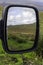 Landscape reflection in car mirror