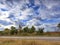 The landscape of the road against the blue sky and the gathering thunderstorm clouds on a summer day