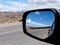 Landscape of road and desert in car mirror