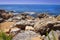 Landscape of rocky beach on blue sea. Scenery seascape on bright sunny summer day on tropical nature. Stones, rocks at coastline