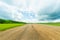 Landscape rural road and blue sky. Straight gravel road leading to the horizon.