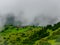 A landscape in Sahyadri mountain with small village. Clouds flowing over the homes. Green ambience is adding more beauty.