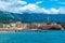 Landscape of sandy Brijeg od Budva beach and old city walls fortress of of old town Budva. Beautiful blue summer sunny