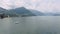 Landscape scene of Como Lake mountains with boats and cloudy sky in Italy on a misty day