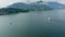 Landscape scene of Como Lake mountains with boats and cloudy sky in Italy on a misty day