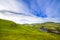 Landscape scenery of green valley, hill, river and cloudy blue s