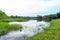 A landscape scenery with a lot of trees, a lake, and a blue sky