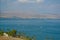 Landscape Sea of Galilee - Sea of Galilee. Blue water, small waves with foam, palm trees, mountains in the distance.