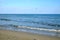 Landscape with sea and skyline with some seagulls in clear blue sky and the coastline on horizon