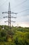 Landscape with several powerful power lines against the green forest and sunset sky, soft focus