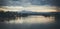 Landscape with shallow lake water and mountains at dusk. Image has analog look.