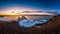 Landscape of Shamanka rock at sunset with natural breaking ice in frozen water on Lake Baikal, Siberia, Russia