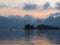 Landscape shot of a beautiful lake with an island in the distance and a person sailing in a canoe