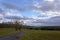 Landscape shot of clouds, grass and mountains in Germany, Vulkaneifel in Rhineland-Palatinate in spring