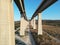 Landscape shot in between the pillars holding a two-part bridge under the clear blue sky