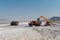 Landscape shot of the process of loading salt onto a truck at Maharlu lake in Shiraz, Iran