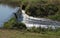 Landscape shot of a small rural waterfall on a spring day