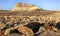 A landscape shot of some petrified trees and mountains at the Petrified Forest National Park in Arizona