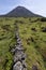 Landscape showing Ponta do Pico mount Pico, Portugal`s tallest mountain and volcano, with lavastone walls in the foreground