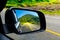 Landscape in the sideview mirror of a car