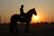 Landscape silhouette photo of a horseman on a horse with sunset.