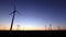 Landscape with the silhouette of the windmills in a wind farm at sunset generating alternative and green energy source