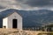 Landscape of a small hermitage with mountains behind on a cloudy day